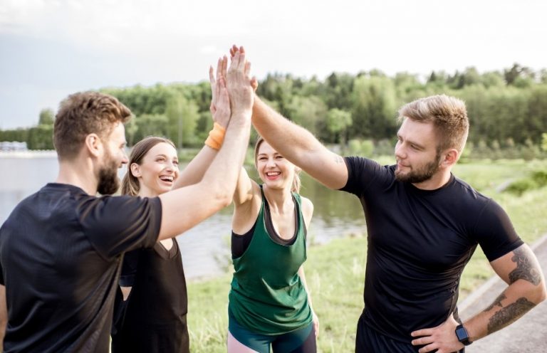 Photo de 4 personnes se tapant dans les mains. Deux hommes et deux femmes.