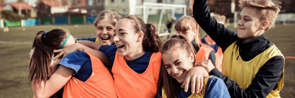 Des jeunes filles se félicitant à la fin d'un match de football