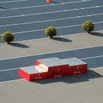 Red podium on a sunny outdoor athletics track with decorative plants.