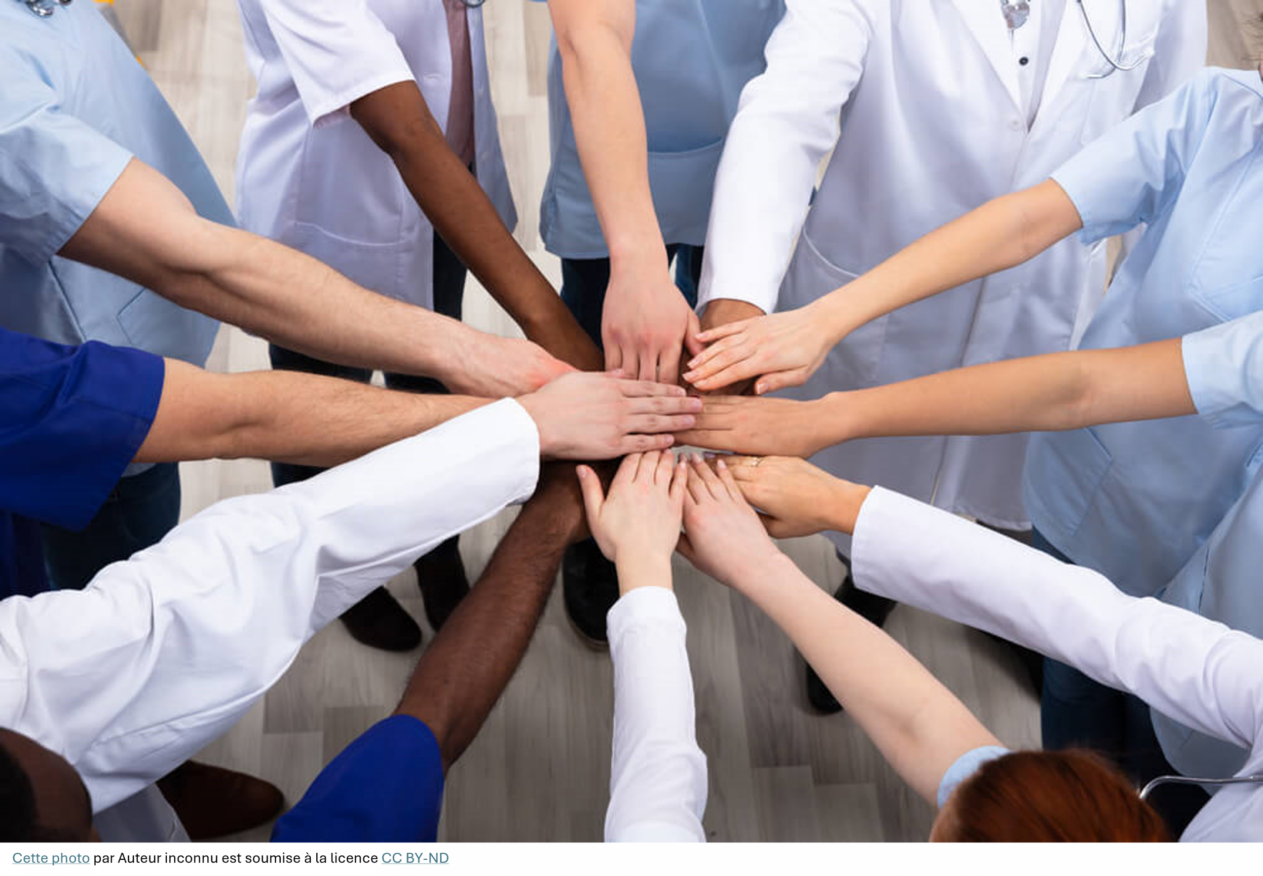 Soignants en blouse qui se mettent leur main au dessus des unes des autres