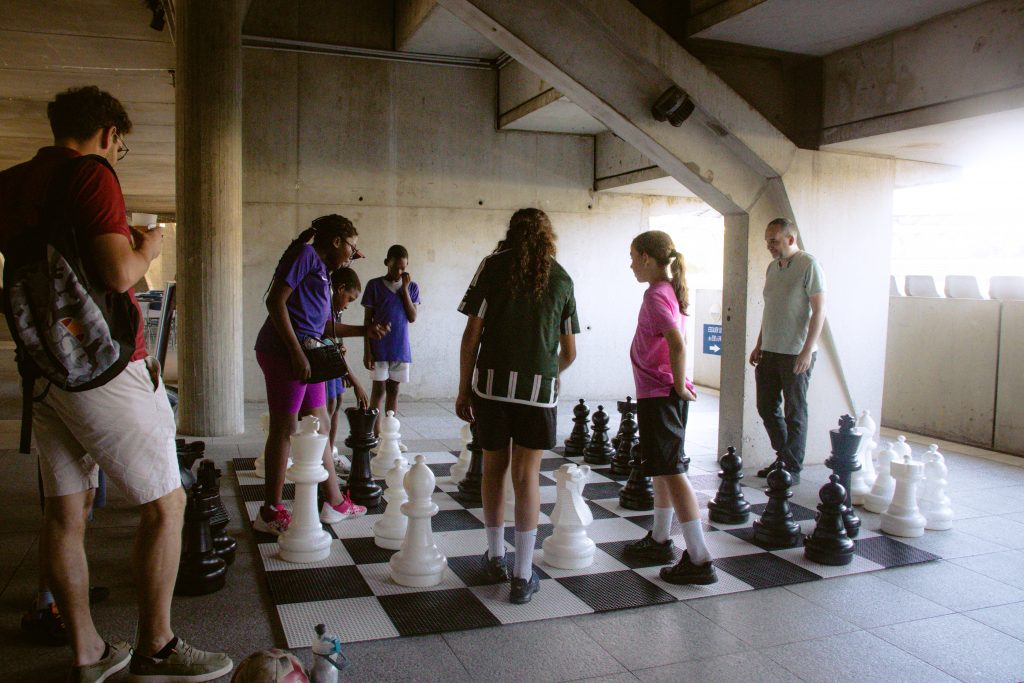 120 ANS-71 Groupe d'adolescents qui jouent aux échecs sur l'échiquier géant